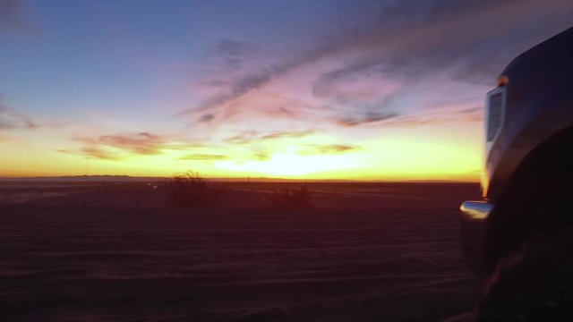 View of desert sunset as dune buggie drives by