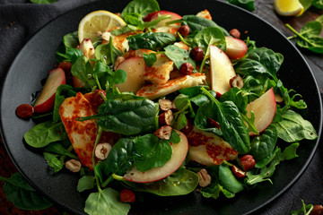 Grilled Halloumi Cheese salad with peach fruit, nuts and spinach, arugula mix. healthy food