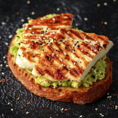 Avocado and grilled haloumi cheese toast with nigella and sesame seeds. healthy breakfast