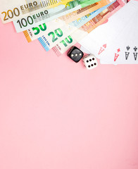 Casino, gambling and fortune concept. Game bones and cards and euro money on pink background with copy space