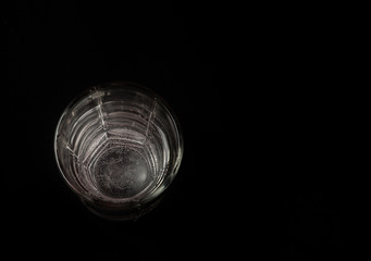 a glass of water on a black background, a place for the text. top view
