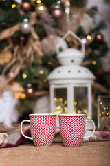 Two Christmas red mugs with holiday decorations 