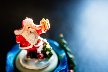 Cute toy Santa Claus on black background