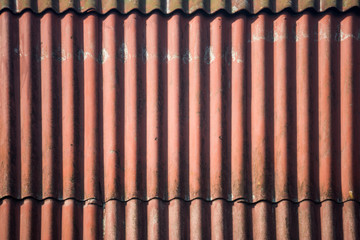 The texture of wavy slate sheets laid overlapped, painted in red and burgundy color