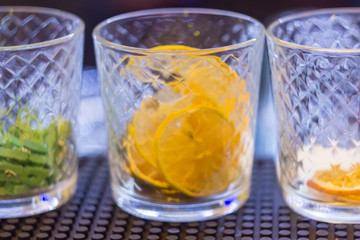 Storing spices, such as dried lemon, in glasses for quick access when preparing drinks