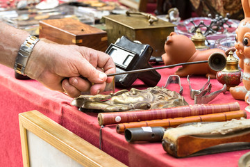 Male hand looking for old objets at a retro - vintage street market in Split, Croatia.