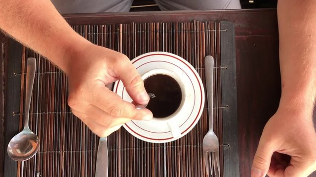 Slow motion of man hand stiring balinese coffee. Bali island.