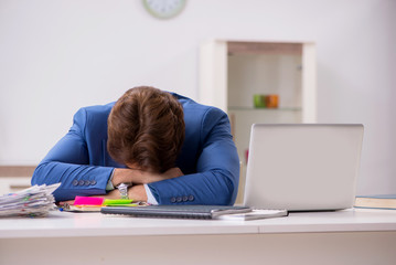 Young attractive businessman working in the office  