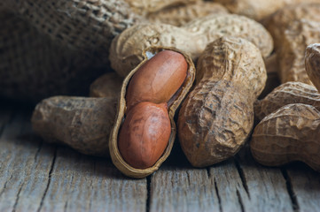 Peanut in nutshell on wooden backrop. Composition of peanuts serving to make oil, peanut butter. Great for healthy and dietary nutrition. Concept of condiments
