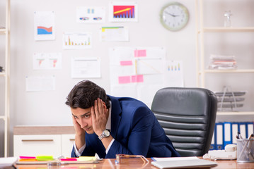 Young handsome sales anayst working at the office