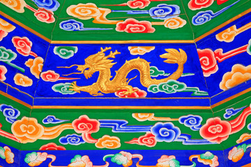 colored drawing gold dragon on wooden board