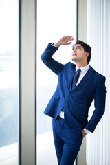 Fototapeta premium Young handsome businessman standing at the window 