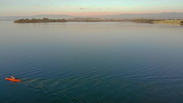 Several different shots of someone paddling a Kayak on a lake in Berekely, NSW, Australia