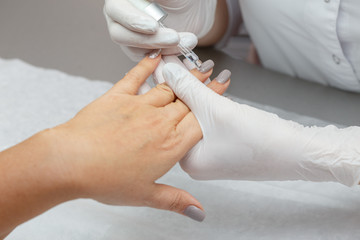 Obraz na płótnie Canvas Therapist lubricating hands of a woman in a beauty salon
