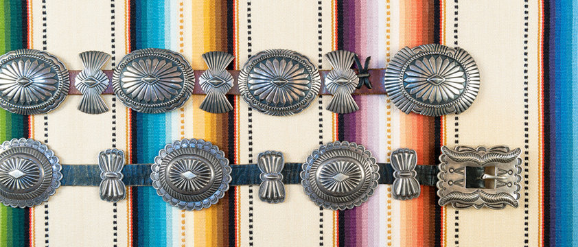 Sterling Silver Native American Concho Belt on Brightly Colored Southwestern Pattern Fabric.
