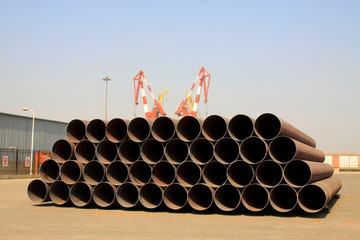 Piles of steel pipe and crane