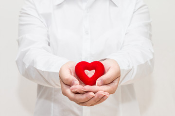 Woman's hand holding a heart shape