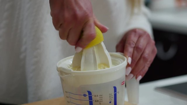 Close-up of a woman using a hand juicer to squeeze fresh lemon juice