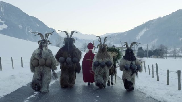 A group of Traditional Krampus walks in Gastein Austria. Folklore during christmas in Salzburg. Mountain village demons with masks and horn during advent. Saint Nicholas and his krampus.
