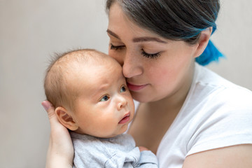 Young mother holding her newborn child. Mom nursing baby.