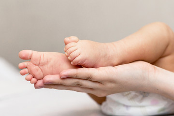 Mother is giving a massage to her newborn son