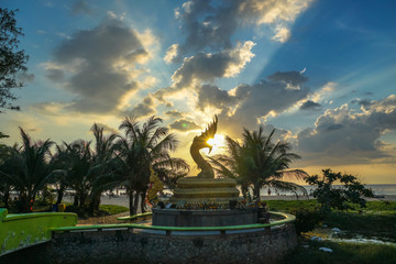 sunset above Naka snake sculpture at Karon beach Naka god of snake statue in the middle of Karon...