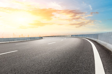 Panoramic city skyline and buildings with empty asphalt road at sunset