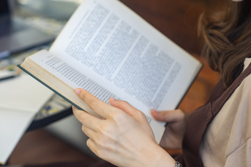Closeup woman hand holding a book to read