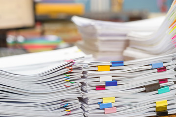 Pile of unfinished document on office desk. Stack of homework assignment archive with colorful...