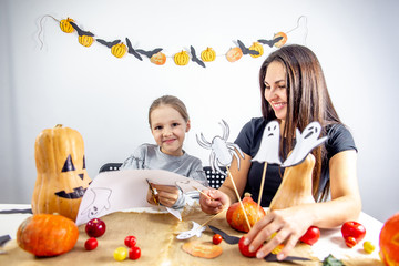 A mother and her daughter carving pumpkin together