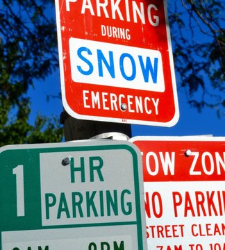 Warning and information street signs for parking and snow emergency on road in Boston 