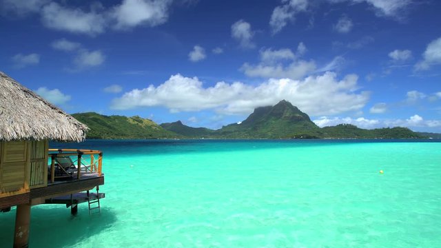 Overwater luxury bungalows and Mt Otemanu in tropical aquamarine lagoon of Bora Bora Island in the South Pacific