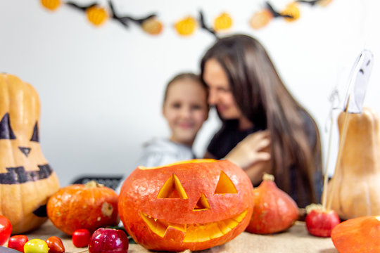 A mother and her daughter carving pumpkin together