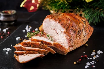 Abwaschbare Fototapete Roasted sliced Christmas ham of turkey on dark rustic background. Festival food. © timolina