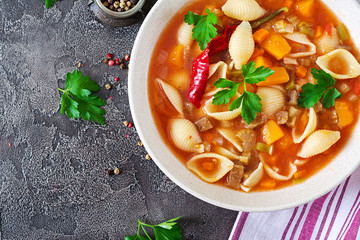Minestrone, italian vegetable soup with pasta on  table. Vegan food. Top view