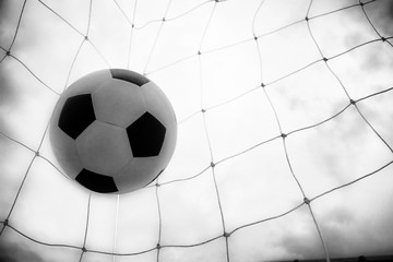 Soccer ball in a net and green background