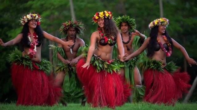 Young males and females in a group of Tahitian hula dancers performing outdoor barefoot in traditional costume Tahiti French Polynesia South Pacific