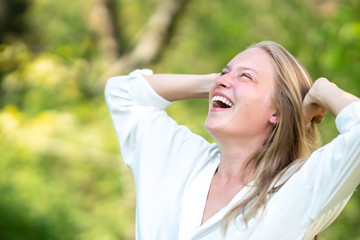 Euphoric woman laughing outdoors in nature