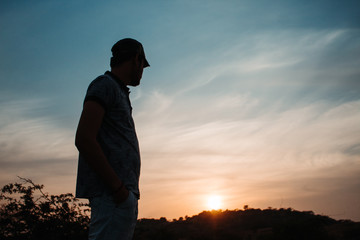 Fototapeta premium Silhouette of man looking at sunset