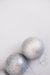 White Christmas background. Glossy silver and glitter decoration balls. Minimalist style. Copyspace for text, overhead