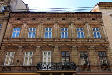 Fototapeta premium Facade of the old building in the city of Lviv. The brown wall with windows