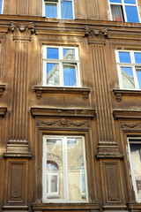 Facade of the old building in the city of Lviv. The brown wall with windows