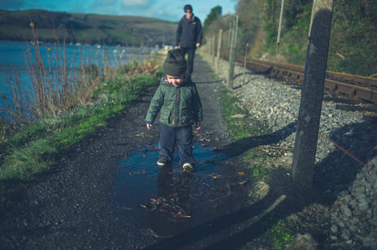 Toddler and grandfather walking by railway tracks
