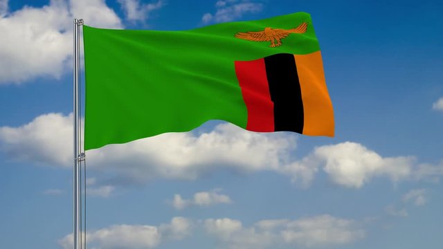 Flag of Zambia against background of clouds floating on the blue sky