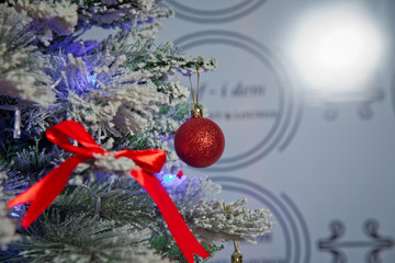 A Christmas red ball hangs on the background of a clock. It's time for a new year. Multicolored...