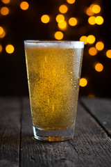 draft beer in a glass on dark  background with blurry lights