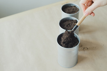 womans hand puts soil in metallic shovel into flowerpot, stock photo image
