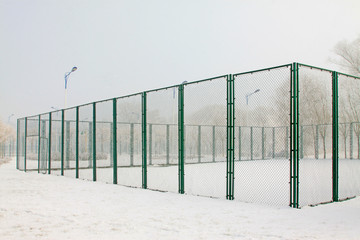 Tennis court fence in the snow