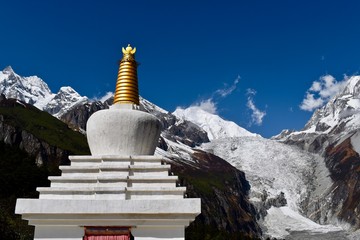 Small stupa and Mt. Gongga with blue sky in the background, Sichuan, China 