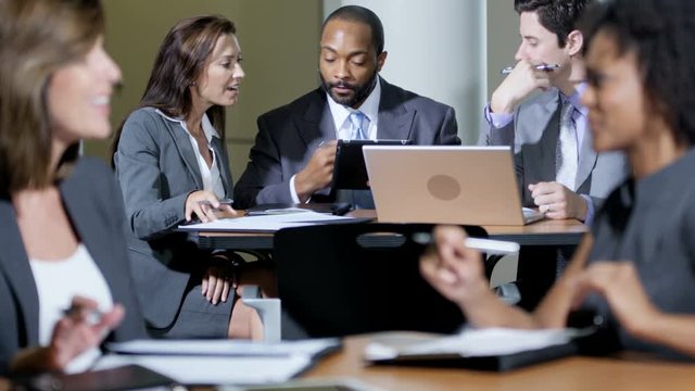 Group of multi ethnic business people using wireless app touchscreen technology meeting in modern office building 